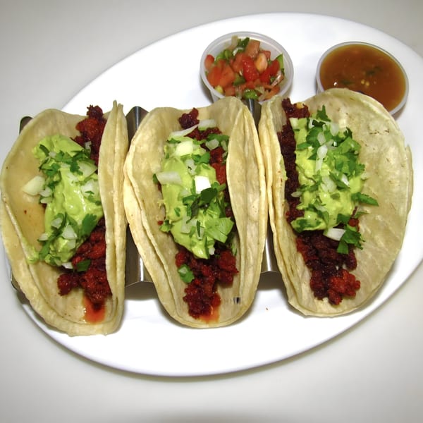Three Old Glory tacos with red meat, guacamole, and cilantro, served with salsa and pico de gallo.